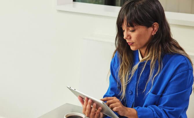 Jeune femme avec tablette assise à une table